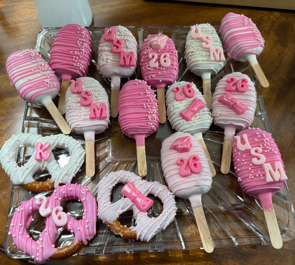 Pink and white graduation dipped treats and pretzels